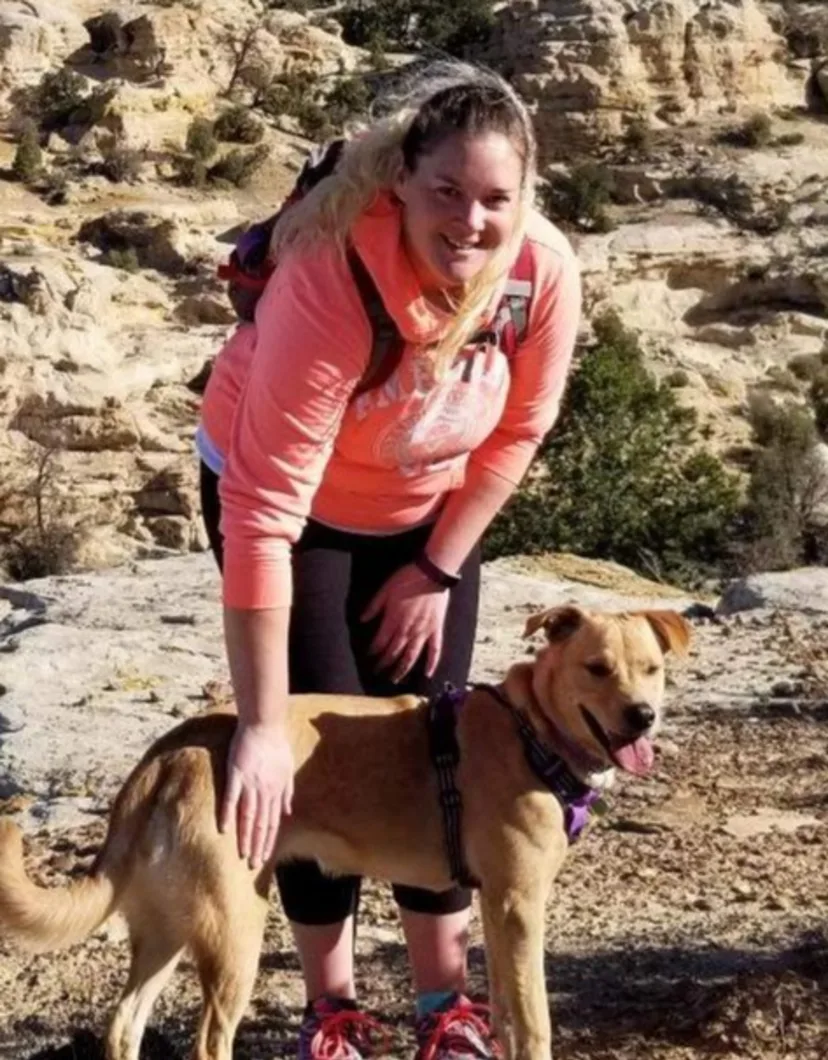 Ashley petting a dog in a desert